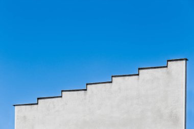 Gökyüzüne çıkan merdiven. Mimari kısmı ve beton bir ev veya merdiven şeklinde bir bina manzarası. Mavi gökyüzü arkaplanına giden yol kavramı.