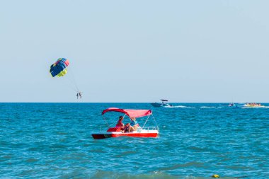 Ukrayna, Demir Liman - 25 Ağustos 2020: Ekstrem sporlar ve heyecan verici dinlenme. Turistler paraşütle uçar denizin üstündeki mavi gökyüzünde ve ufuk çizgisi arka planında..