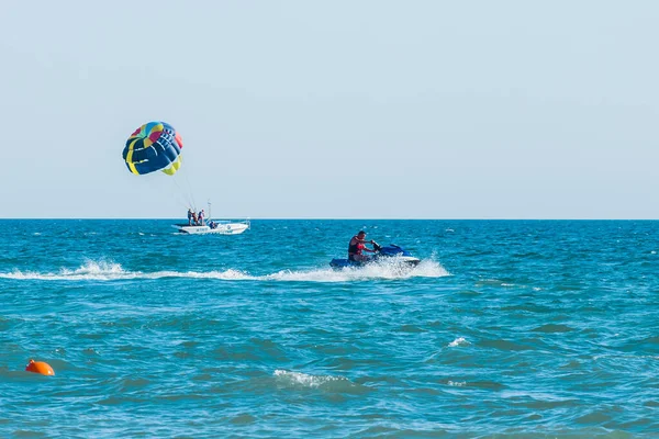 乌克兰 2020年8月25日 极限运动和令人兴奋的休息 一名男子在地平线的背景下骑着一辆水上飞机在蓝色的海面上 还有乘坐汽艇的观光客 — 图库照片