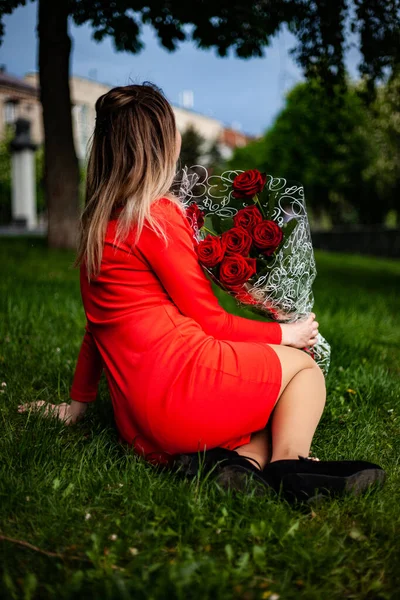 Una niña que está sentada en la hierba —  Fotos de Stock