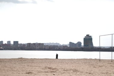 Büyük, yalnız, güzel bir şehir, durgun bir akşamda, suyun üzerinde.