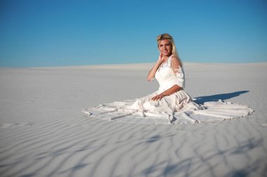 Gelinlik giymiş güzel gelin kumların üzerinde.