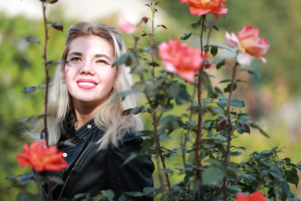 Retrato de una hermosa niña de cerca en flores en el jardín —  Fotos de Stock