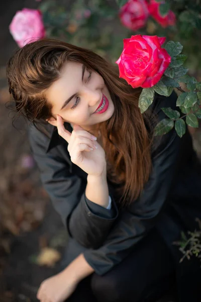 Retrato de una hermosa niña de cerca en flores en el jardín —  Fotos de Stock