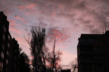 Arkasında günbatımı olan bir bina.