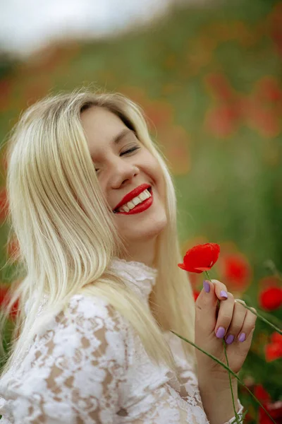 Hermosa chica en un campo con amapolas rojas en un traje de cuerpo transparente —  Fotos de Stock