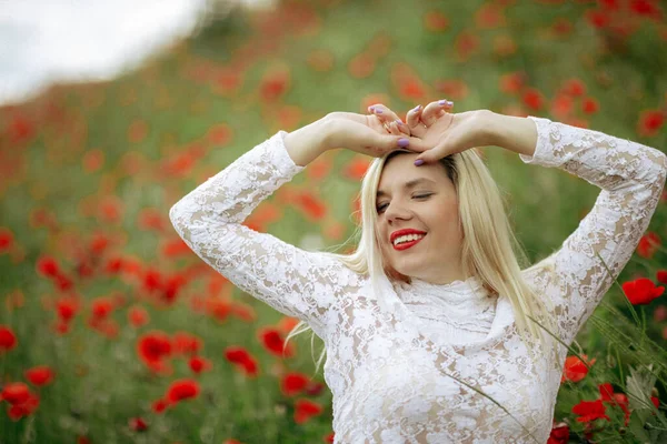 Hermosa chica en un campo con amapolas rojas en un traje de cuerpo transparente —  Fotos de Stock