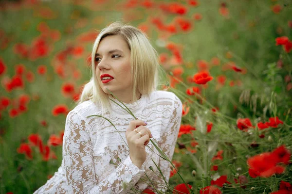 Hermosa chica en un campo con amapolas rojas en un traje de cuerpo transparente —  Fotos de Stock
