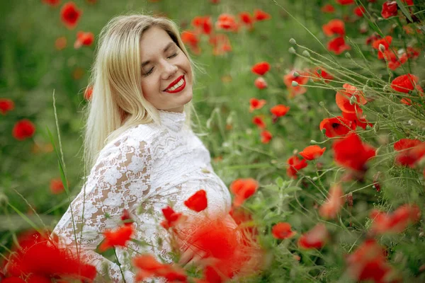 Hermosa chica en un campo con amapolas rojas en un traje de cuerpo transparente —  Fotos de Stock