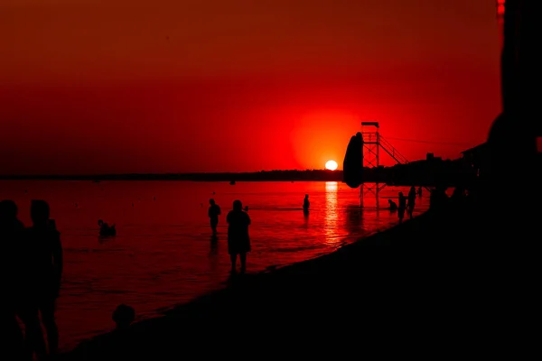 Sol al atardecer junto al océano, agua clara y playa azul arenosa — Foto de Stock