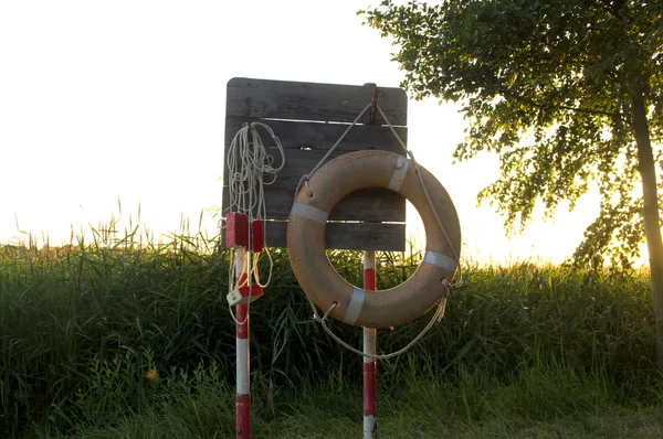 带附件的木制盾牌, 以节省日落时的水 — 图库照片