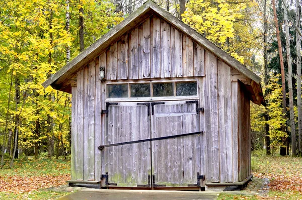 秋の森を背景に車のための木造ガレージが立つ — ストック写真