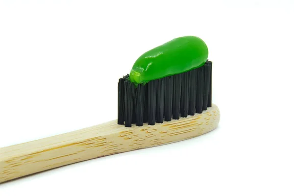 Cepillo de dientes de bambú con pasta de dientes de menta verde aislada sobre fondo blanco. — Foto de Stock