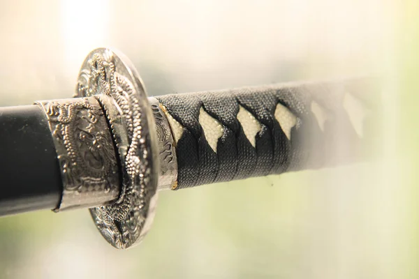Japanese sword katana with roped handle close-up.