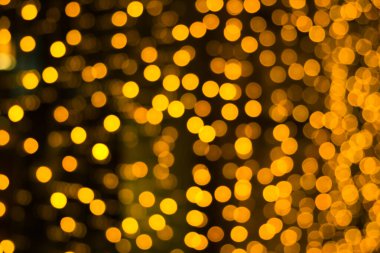 Bokeh efektli turuncu ve sarı ışıklı soyut bir arkaplan. Noel kutlaması kavramı.