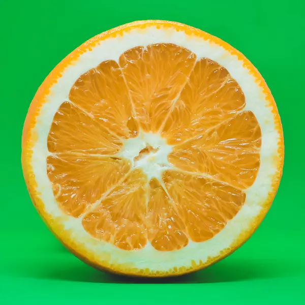 Plasterki pomarańczy izolowane na zielonym tle. — Zdjęcie stockowe