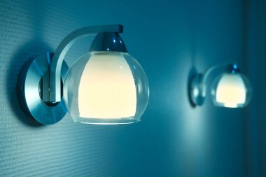 Yatak odasında bir çift lamba ışığı. İki gece lambasının mavi ve sarı renkli görüntüsü.