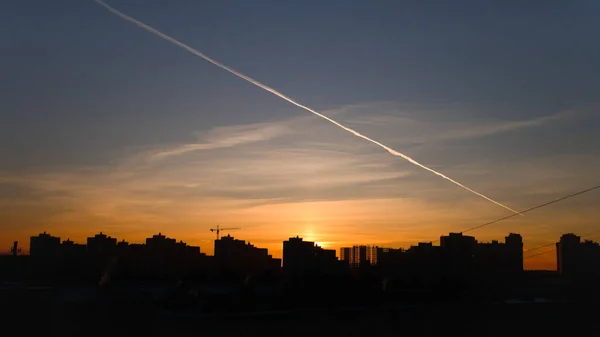 Prachtige zonsopgang in de stad. De silhouetten van de stad gebouwen en knapheid morgen lucht verlichten door de rijzende zon. — Stockfoto