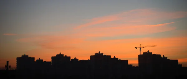 Hermoso amanecer en la ciudad. Las siluetas de los edificios de la ciudad y la belleza del cielo de la mañana iluminado por el sol naciente. — Foto de Stock