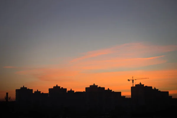 De silhouetten van de stad gebouwen en schoonheid morgen lucht en bewolking verlichten door de rijzende zon. — Stockfoto