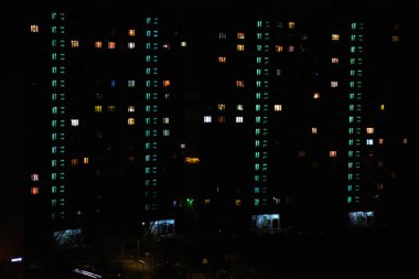 Apartman pencerelerindeki karanlık gece manzarası