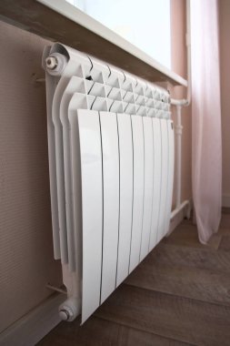 Modern home heating radiator under the window. Bimetal, aluminium radiator. Heating system.