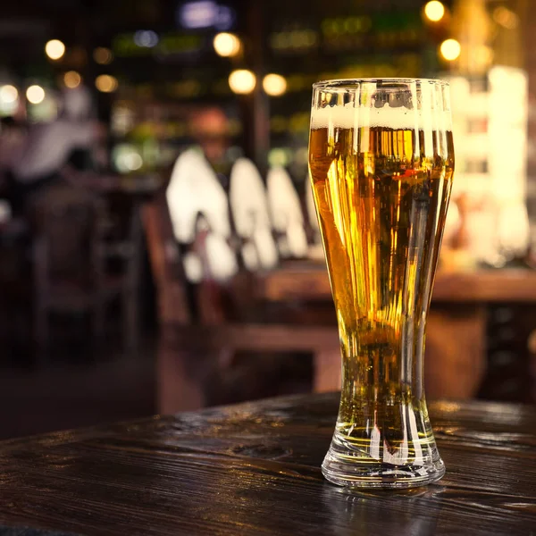 Ett glas kall öl på baren eller puben. Dimmig backgrounnd av bar lampor. — Stockfoto