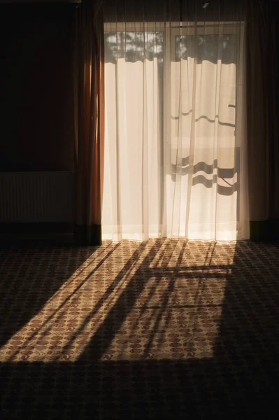 Frammento astratto di un interno. Arco della porta del balcone con tulle trasparente e il sole luminoso all'esterno — Foto Stock