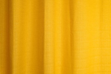 Katlı kumaş sarısı perdeler. Soyut arkaplan, perde, altın kumaş perdeler.