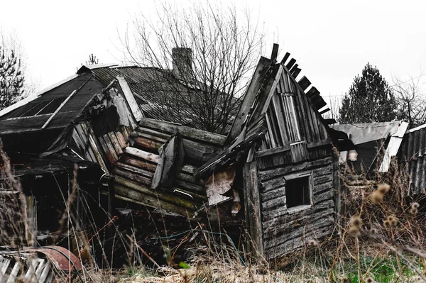 Oud verwoest verlaten houten huis. Rustiek gebroken gebouw. — Stockfoto