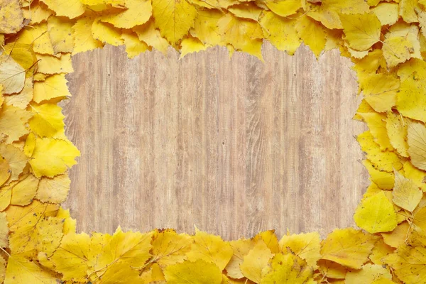 Jasnożółta jesienna ramka opadłych liści na drewnianym tle z białą kopią miejsca na reklamę. Jesienna koncepcja rabatowa. — Zdjęcie stockowe