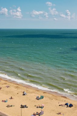 İnsanlar açık denize yakın bir plajda 