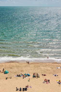 İnsanlar açık denize yakın bir plajda 