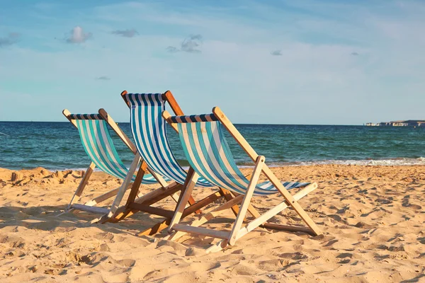 Three beach chairs on golden beach — Stock Photo, Image