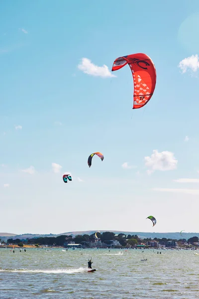 Saltatori di paracadute che sorvolano il mare Fotografia Stock