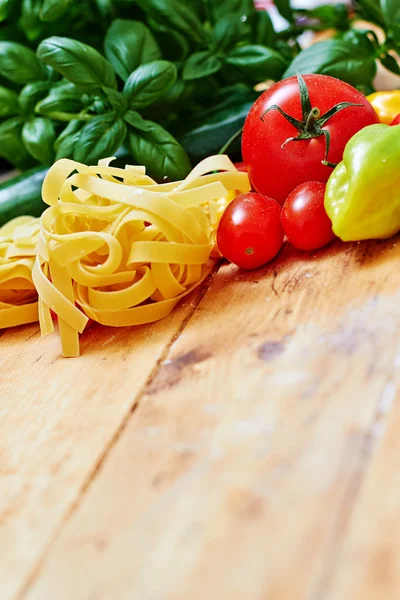 Tagliatelle crudo con verduras sobre mesa de madera —  Fotos de Stock