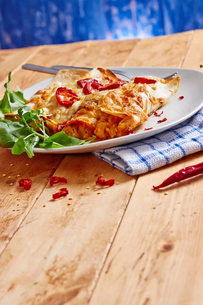 Prato de enchiladas com pimentas vermelhas na mesa de madeira — Fotografia de Stock