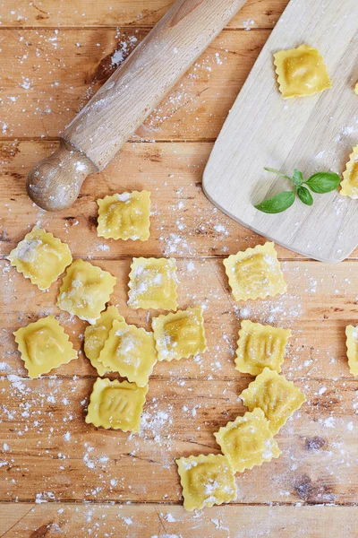 Massa de ravioli crua na mesa de madeira — Fotografia de Stock