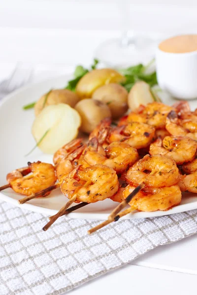 Grilled shrimp on skewer with potatoes and sauce — Stock Photo, Image