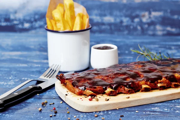 Costelas de churrasco com batatas fritas na mesa — Fotografia de Stock