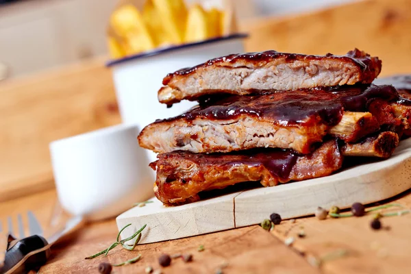 Costillas de barbacoa con papas fritas en la mesa —  Fotos de Stock