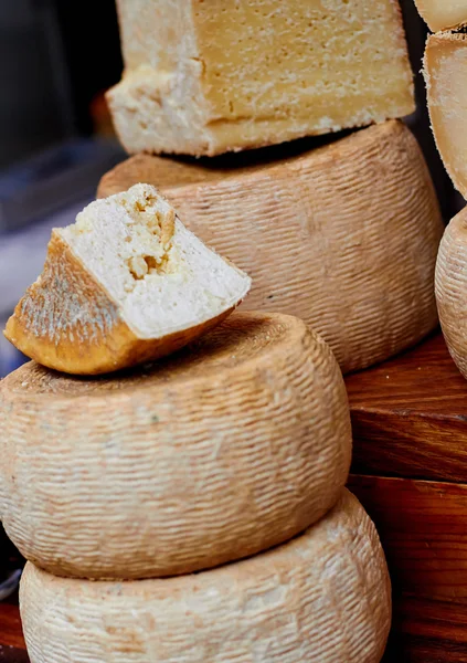 Cow milk cheese, stored in a wooden shelves — Stock Photo, Image