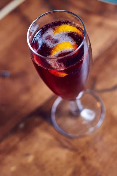 Cóctel de alcohol rojo con rodaja de naranja — Foto de Stock