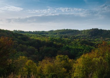 Güneşli gökyüzünün altındaki gölgeli dağ manzarası