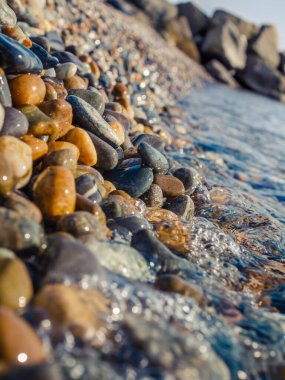 Güneşli bir günde denizde çakıl taşları ve taşlar
