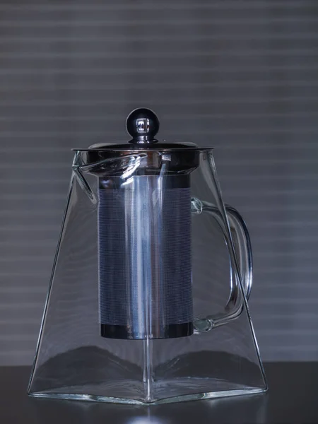 Bir masanın üzerindeki cam çaydanlık: çizgili arka planlı natürmort