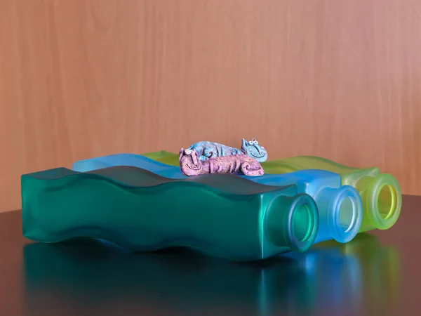 Üç renkli vazoda iki kedi oyuncağı var.