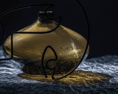 Göz şeklindeki soyut kompozisyon ve cam vazo