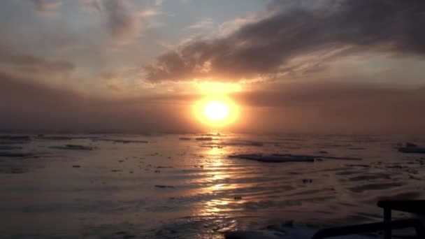 Coucher de soleil dans l'océan parmi les icebergs et la glace en Arctique .