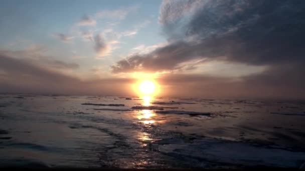 Sonnenuntergang im Ozean zwischen Eisbergen und Eis in der Arktis. — Stockvideo